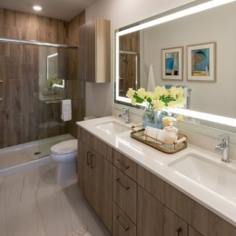 a spacious bathroom with a large mirror and ample light