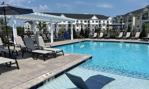 a pool with chairs and umbrellas by it