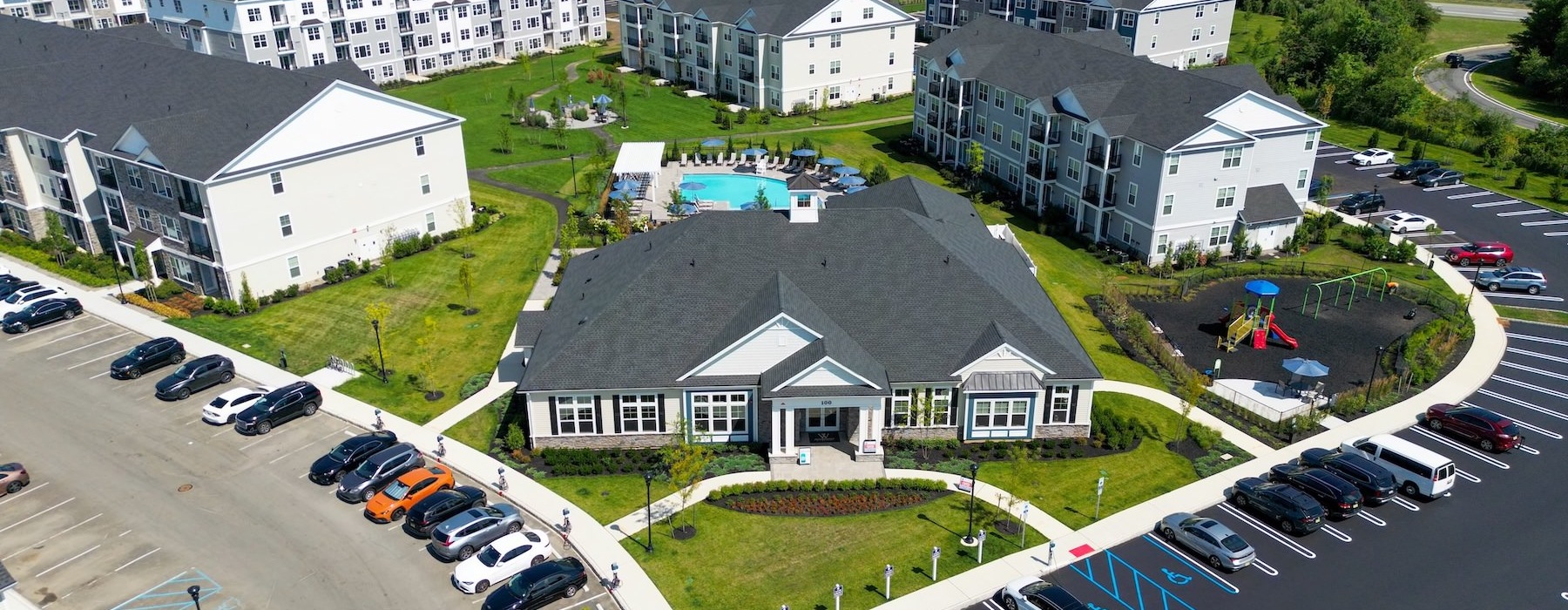 an aerial view of a number of buildings and cars and a lawn